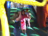 children bounce inside the Rainbow jump, cllimb and slide combo